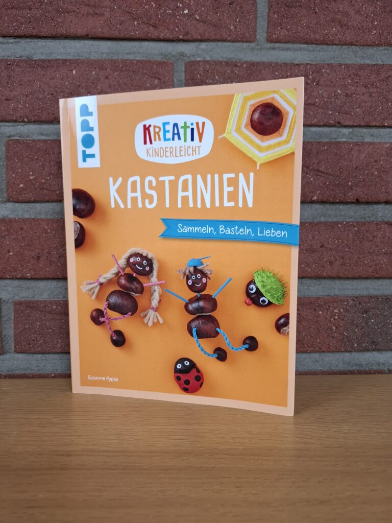 Bastelbuch „Kreativ kinderleicht Kastanien“ von Susanne Pypke vor einer Ziegelwand