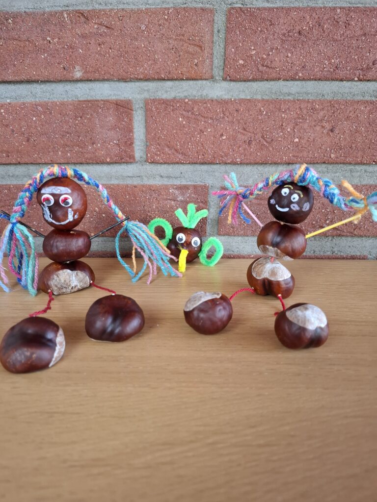 Fertige Kastanienfiguren aus dem Bastelbuch auf einem Holztisch