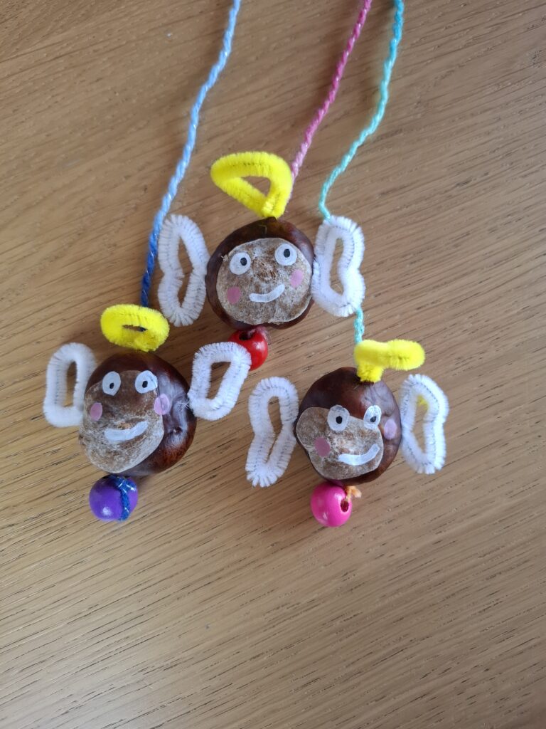 Fertige Kastanienfiguren aus dem Bastelbuch auf einem Holztisch