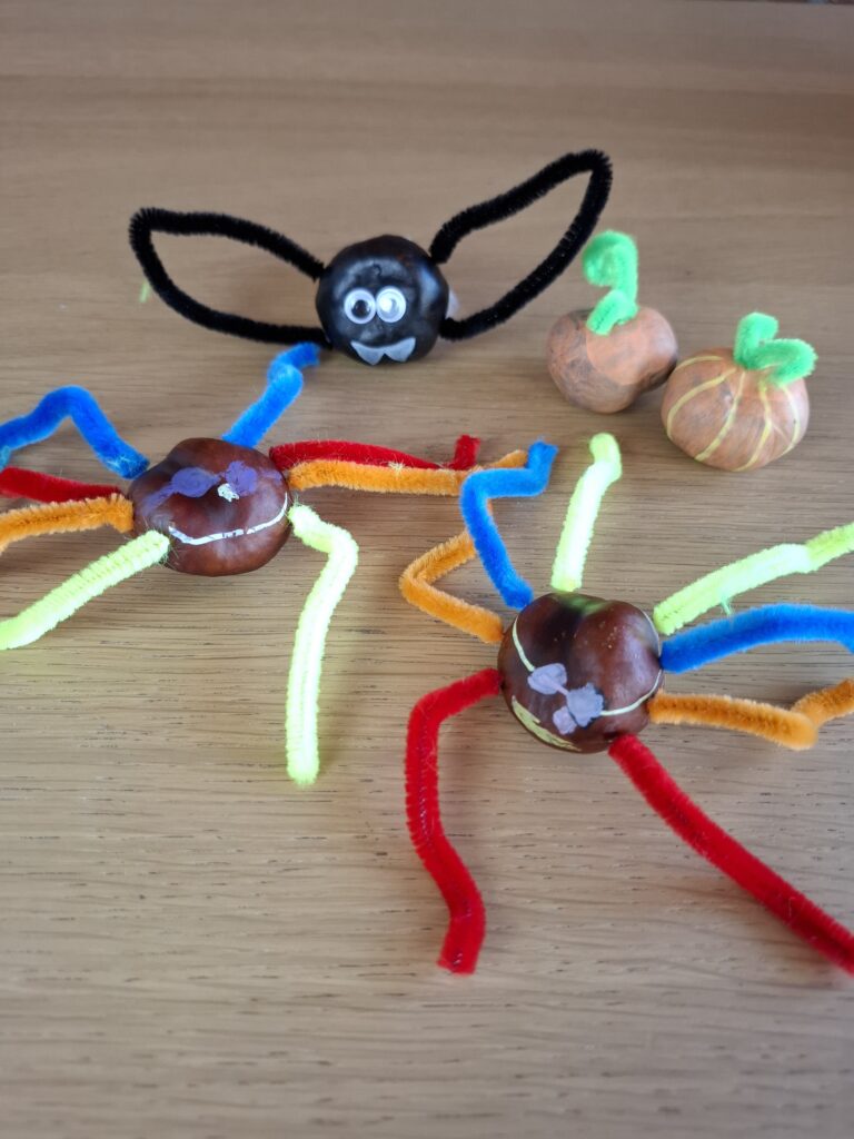 Fertige Kastanienfiguren aus dem Bastelbuch auf einem Holztisch